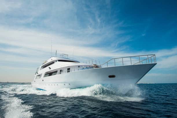 A luxury private motor yacht under way on tropical sea with bow wave